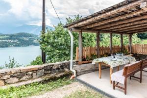 een patio met een tafel en uitzicht op het water bij Residenza Glicine in Pergine Valsugana