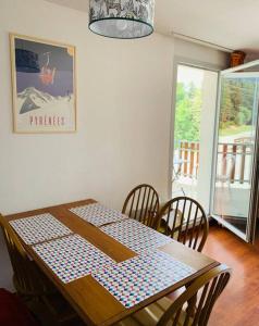 uma mesa de jantar e cadeiras com uma mesa estampada azul e branca sidx sidx em T3 - 6 PERS - PIEDS DES PISTES + PISCINE BALCON em Ax-les-Thermes