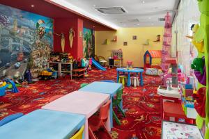 a childrens play room with tables and play equipment at Pirin Park Hotel in Sandanski