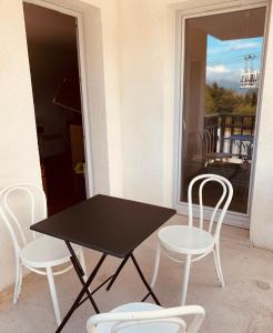 une table et des chaises noires sur une terrasse couverte avec un balcon dans l'établissement T3 - 6 PERS - PIEDS DES PISTES + PISCINE BALCON, à Ax-les-Thermes