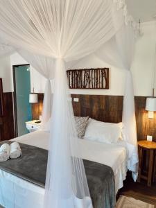 a bedroom with a white bed with a canopy at Quinta da Bocaina in Amparo