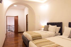 Suites Experience by Hotel David في كيتو: غرفة نوم بسريرين وطريق ارضي