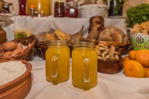 two jars of orange juice on a table with baskets of food at Sea View Village in Vasilikos