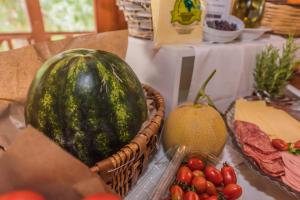 a table with a melon and other fruits and vegetables at Sea View Village in Vasilikos