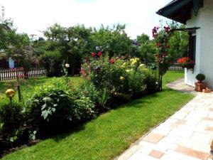 a garden with colorful flowers and a fence at Haus Huber in Übersee