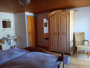 a bedroom with a bed and a sink and a cabinet at Haus Huber in Übersee
