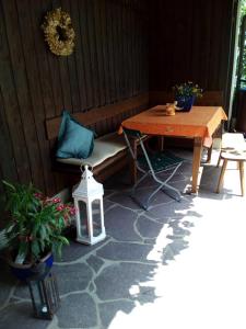 a patio with a table and a bench and plants at Haus Huber in Übersee
