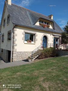 a white house with a blue door and a yard at LA PETITE MEUNIERE 