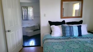 um quarto com uma cama com um espelho e um lavatório em Tropical Coast Retreat - Pet Friendly - Adult only em Kingscliff