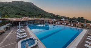 a large swimming pool with a mountain in the background at Sea View Village in Vasilikos