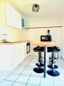 - une cuisine avec un comptoir et des tabourets dans l'établissement Charmant appartement 2 chambres 400 m centre gare, à Valence