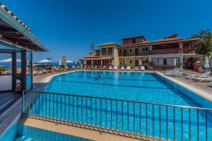 a large swimming pool next to a house at Sea View Village in Vasilikos