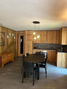 a dining room with a table and chairs and a kitchen at Remina Dolomiti house in Tonadico