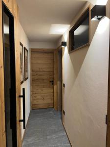 un pasillo con una puerta de madera en una casa en Remina Dolomiti house, en Tonadico