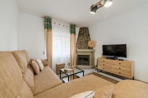 uma sala de estar com um sofá e uma televisão em Chalet con piscina en entorno idílico em La Zubia