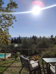 eine Terrasse mit einem Tisch, einem Stuhl und einem Pool in der Unterkunft Podere Borgaruccio in Peccioli