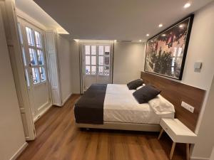 a bedroom with a king sized bed and two windows at Old Town Flats Casa del Bisbe in Valencia