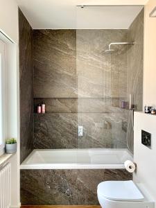 y baño con bañera y aseo. en Live Lugano - Via Madonetta, en Lugano