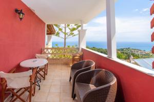 a balcony with chairs and a table and the ocean at Sea View Village in Vasilikos
