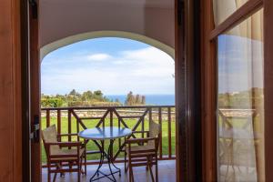 a room with a balcony with a table and chairs at Sea View Village in Vasilikos