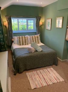 una camera con due letti e una finestra di Fletchers Cottage a Honiton