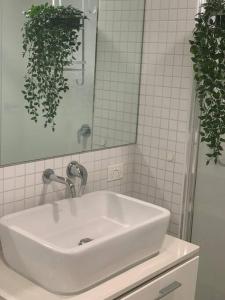 lavabo blanco en el baño con espejo en Carlton Stunning View Apartment 150m away from University of Melbourne, en Melbourne