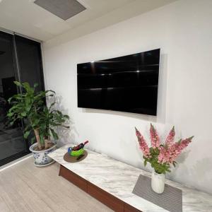 uma sala de estar com uma televisão de ecrã plano na parede em Carlton Stunning View Apartment 150m away from University of Melbourne em Melbourne