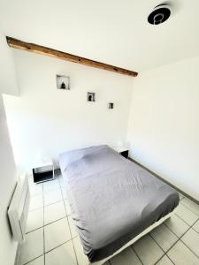 - une chambre avec un lit dans un mur blanc dans l'établissement Charmant appartement 2 chambres 400 m centre gare, à Valence