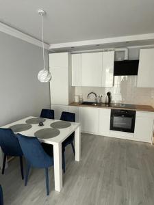 a kitchen with a table and chairs in a room at Apartament Jantar Osiedle Bursztynowe Jantar PROMOCJA in Jantar