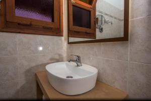 a bathroom with a white sink and a mirror at Sea View Village in Vasilikos