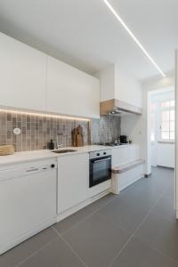 uma cozinha branca com armários e electrodomésticos brancos em Casa Boma Lisboa - Charming and Spacious Apartment - Campolide II em Lisboa