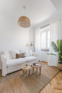 a white living room with a white couch and a table at Casa Boma Lisboa - Charming and Spacious Apartment - Campolide II in Lisbon