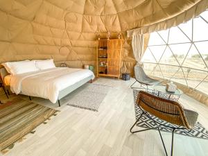 a bedroom with a bed and a chair in a tent at Pura Eco Retreat, Jubail Island in Abu Dhabi