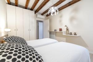 a bedroom with two beds and a chandelier at CA FOSCA HOME - Campo Santa Fosca in Venice