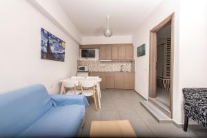 a living room with a blue couch and a kitchen at Sea View Village in Vasilikos