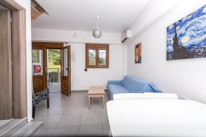 a living room with a blue couch and a table at Sea View Village in Vasilikos