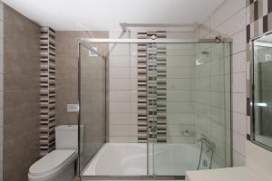 a bathroom with a tub and a toilet and a shower at Sea View Village in Vasilikos