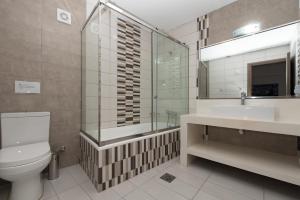 a bathroom with a toilet and a sink and a mirror at Sea View Village in Vasilikos