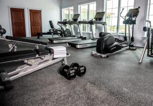 une salle de sport avec plusieurs tapis de course et appareils d'exercice dans l'établissement Oaks on the River, à Darien