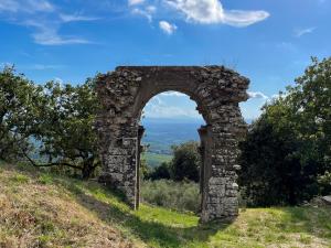 an arch in a stone wall on a hill at Agriturismo Cetamura in Castelnuovo Berardenga