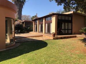 una casa con un patio de hierba delante de ella en Eliora, en Randfontein