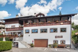 a white building with a balcony on top of it at Pension Sonia App 104 in Funes