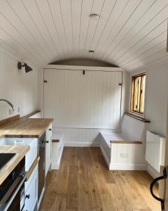 a kitchen with white walls and wooden floors and a window at Robins Retreat - orchard with hot tub - see extras in Alfriston