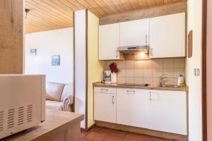 a kitchen with white cabinets and a sink at Pension Sonia App 104 in Funes