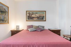um quarto com uma cama com uma colcha rosa em La Coccola di Giovanni em Levico Terme