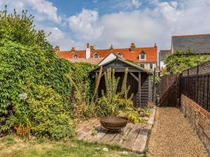 a small garden with a fence and a basket at Pass the Keys Delightful 2 Bed House a Stones Throw From Beach in Bognor Regis