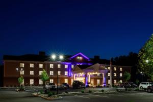 a hotel at night with purple lights at Holiday Inn Express & Suites - Sturbridge, an IHG Hotel in Sturbridge