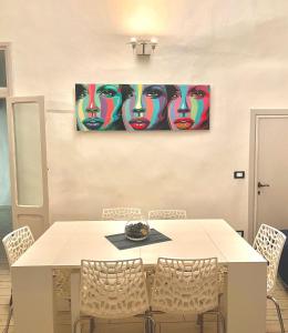 una mesa de comedor con sillas y una pintura en la pared en Appartamento Merilu, en Civita Castellana