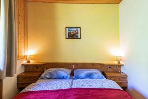 a bedroom with a bed with two blue pillows at Pension Sonia App 103 in Funes