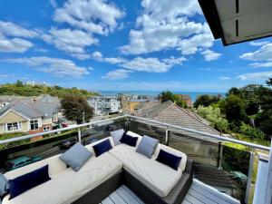 a balcony with a white couch and blue pillows at The Beach Hytte - Stunning Sea View Penthouse in Bournemouth